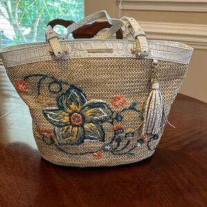 Brahmin straw with white trim and flower on front.